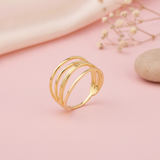 gold layered Strata ring on a pink background with draped satin fabric and dried baby's breath