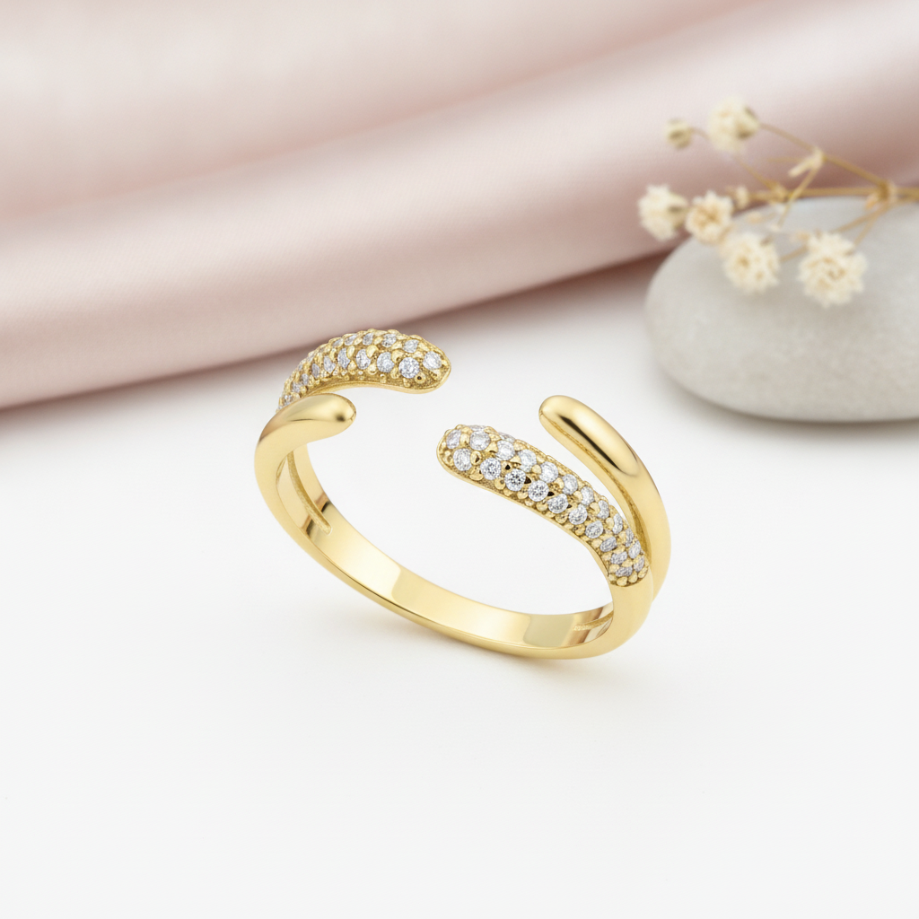 gold open bypass Solis ring with pave-set stones on a pink background with draped satin fabric and a rose quartz stone