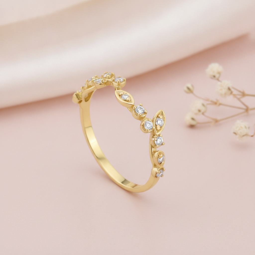 gold vine ring with White CZ leaf stones on a blush pink background with draped satin fabric and baby's breath