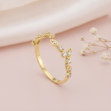 gold vine ring with White CZ leaf stones on a blush pink background with draped satin fabric and baby's breath