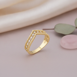 gold chevron ring with beaded borders and White CZ stones on a mauve background with draped satin fabric, a eucalyptus leaf, and a pink stone