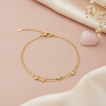 gold double chain bracelet with square stone stations, styled with dried flowers and a pink stone on a blush background