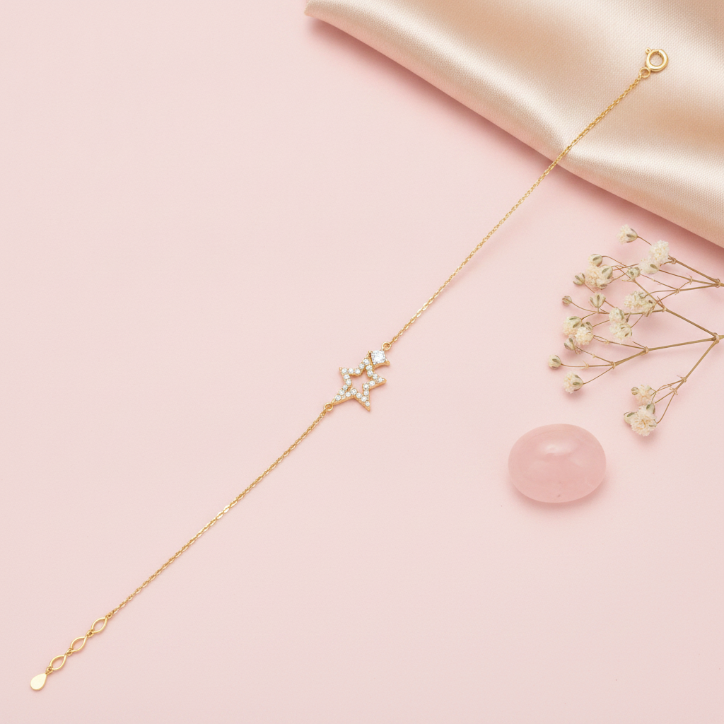 gold chain bracelet with an open pave star charm on a blush pink background with baby's breath and a rose quartz stone