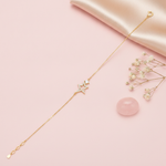 gold chain bracelet with an open pave star charm on a blush pink background with baby's breath and a rose quartz stone