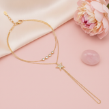 gold hand chain bracelet with bezel-set stones and a pave star motif extending to a finger loop on a blush background with a peony and a rose quartz stone
