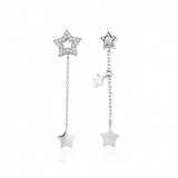 white gold Astra asymmetrical star drop earrings on a white background