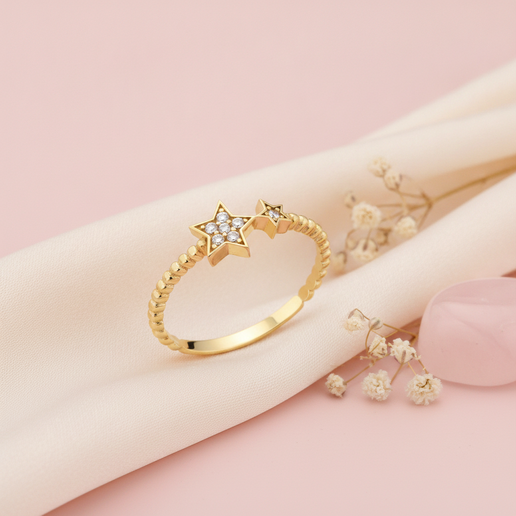 textured gold ring with twin star motifs set with White CZ stones on a pink backdrop with dried flowers