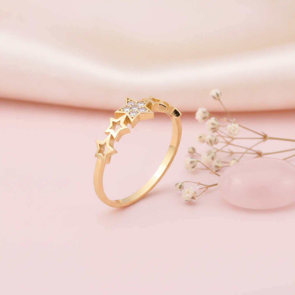 gold ring with a stone-set central star and a sequence of open star silhouettes on a blush backdrop with dried flowers and a rose quartz stone