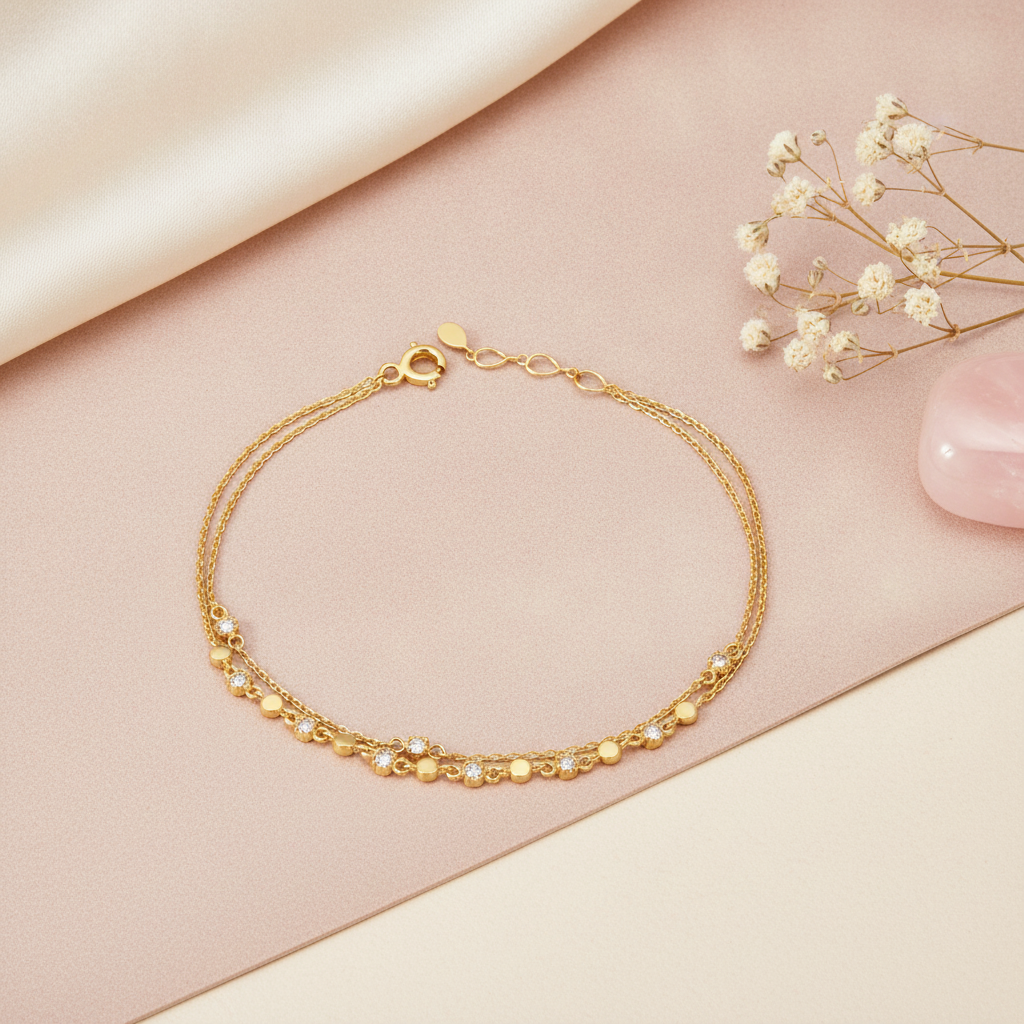 double-strand gold chain bracelet with beads and stones on a blush backdrop with dried baby's breath and a rose quartz stone