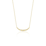 beaded arc necklace in yellow gold on a white background