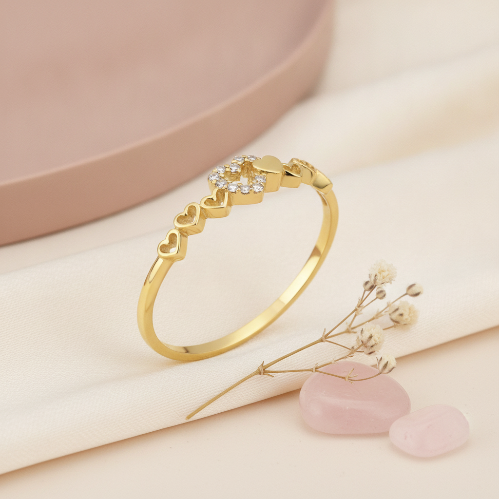 gold twin heart ring displayed on pink and cream satin with dried baby's breath and rose quartz stones