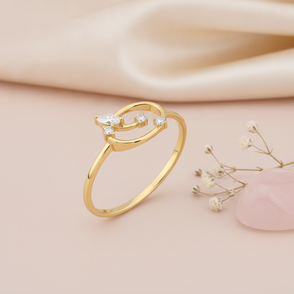 gold open loop ring with marquise and round stones displayed on pink satin with dried baby's breath and a pink stone