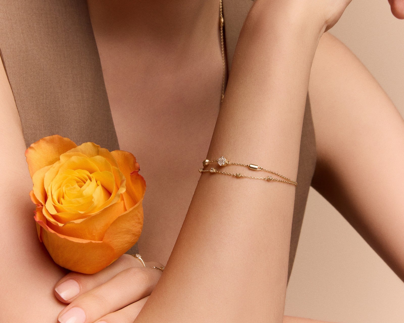two delicate gold chain bracelets on a wrist