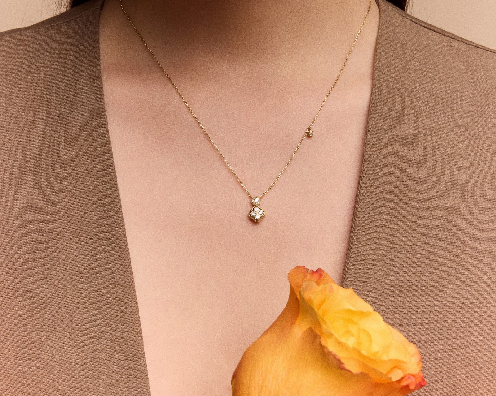 gold clover pendant necklace on a neckline